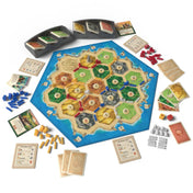 A Catan telepesei 2025-ös kiadásának játéktáblája az összes tartozékkal: hatszögletű mezők, erőforrás- és fejlesztéskártyák, színes bábuk, dobókockák, játékoskártyák és tárolók.