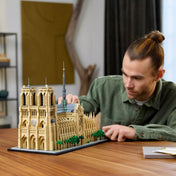 Egy személy a LEGO Architecture Notre-Dame de Paris (21061) készletet építi asztalon, a részleteken dolgozik koncentráltan.