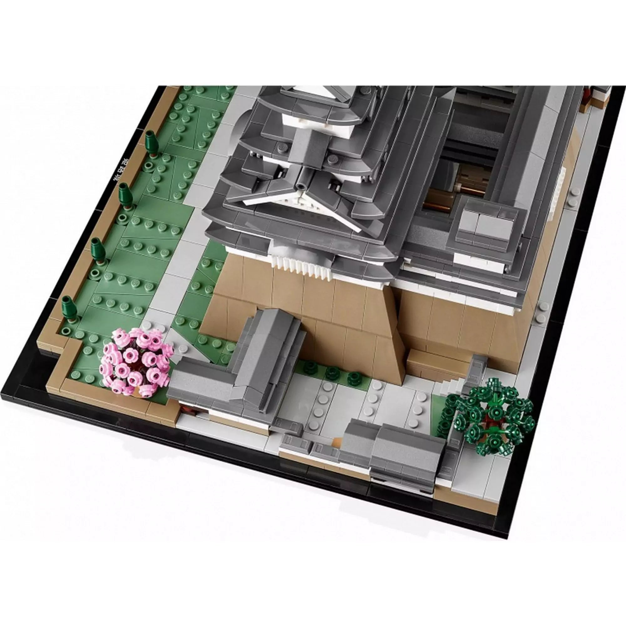 LEGO Himedzsi várkastély (21060) modell közelről, a sarkon lévő rózsaszín virágú fával és a kastély díszes tetőszerkezeti részletével.
