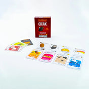 A képen a Robbanó Cicák Mini társasjáték tartalma látható kibontva. Középen helyezkedik el a játék piros színű doboza, rajta a jól ismert lángszórós macskával. Körülötte színes, humoros illusztrációval ellátott kártyák sorakoznak, amelyek mindegyike egyedi akciót vagy karaktert ábrázol – például a „TACOCICA”, a „SZŐRBOCS”, vagy a „SZELLEM CICA”. A különleges kártyák mind a játékosok taktikázását és túlélési esélyeit befolyásolják.