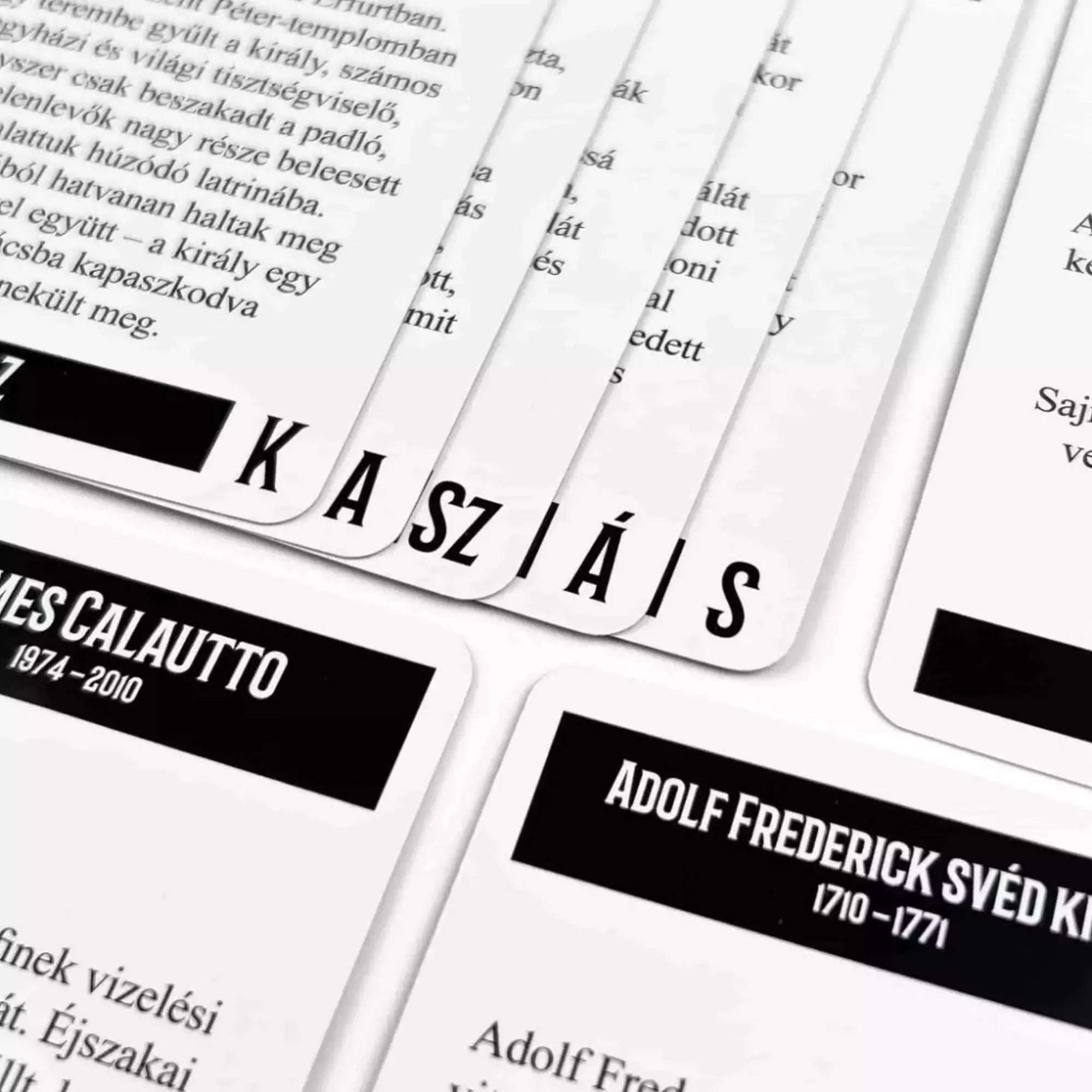 Az Aki hülye, haljon meg! társasjáték kaszás betűit kirakó, fekete-fehér kártyái közelről.