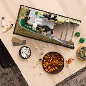 LEGO Architecture: Neuschwanstein kastély (21063) építés közben, LEGO elemekkel és részletes alappal az asztalon.