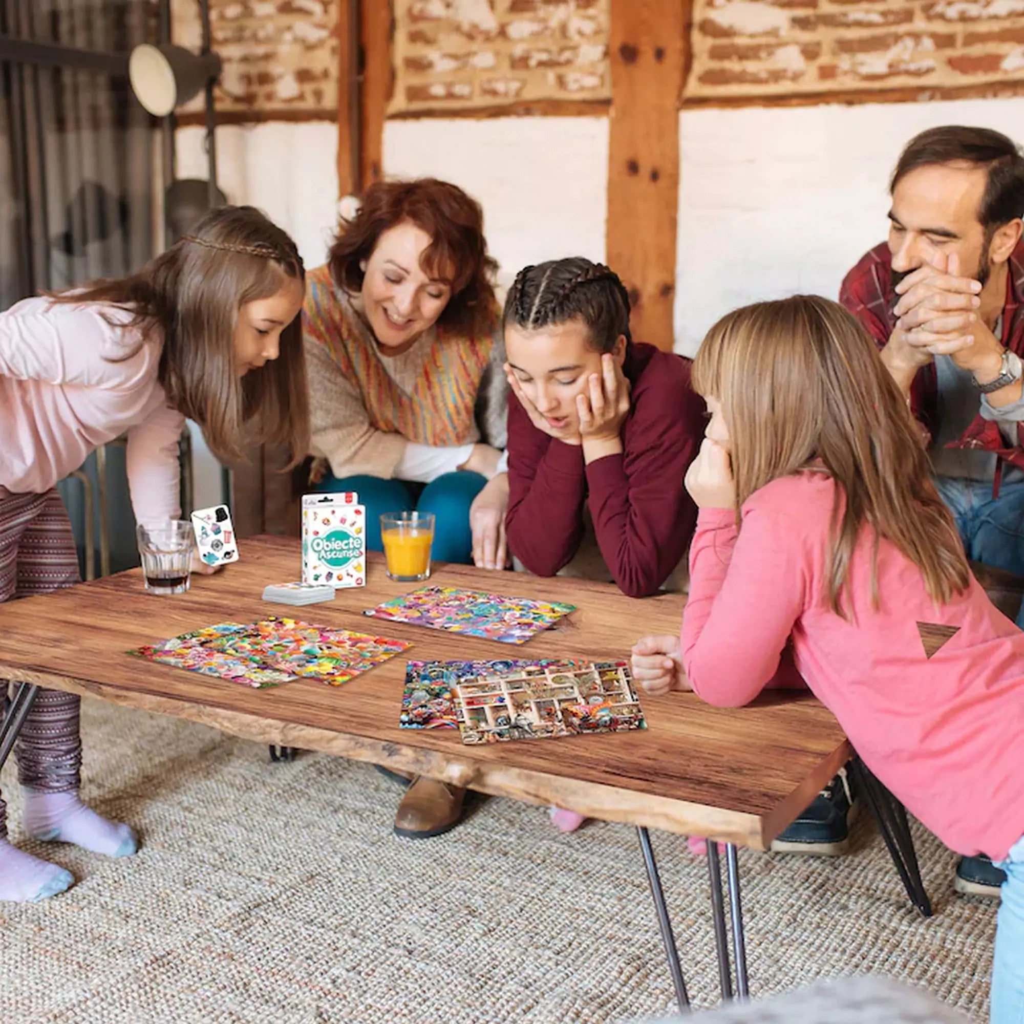 „Család Obiecte Ascunse társasjátékkal játszik egy faasztalon, színes játéktáblák és kártyák társaságában.”