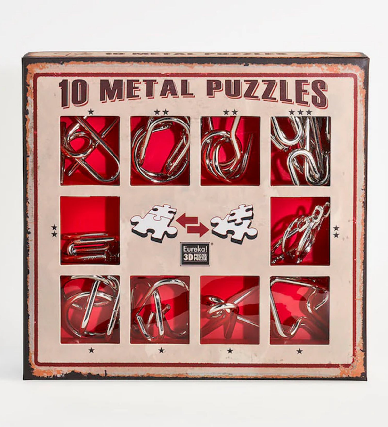 A 10 Metal Puzzle Set díszdoboza, amely piros háttérrel és retró stílusú barna kerettel emeli ki a tíz különböző formájú fém logikai játékot; a doboz elején kirakós darabokat ábrázoló ikonok és a Eureka! 3D Puzzle logó is látható.