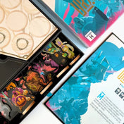 Az Uralkodó társasjáték nyitott doboza felülről fotózva, belsejében fa figurák, karton elemek, játéktábla és szabálykönyv rendszerezett betéttel.