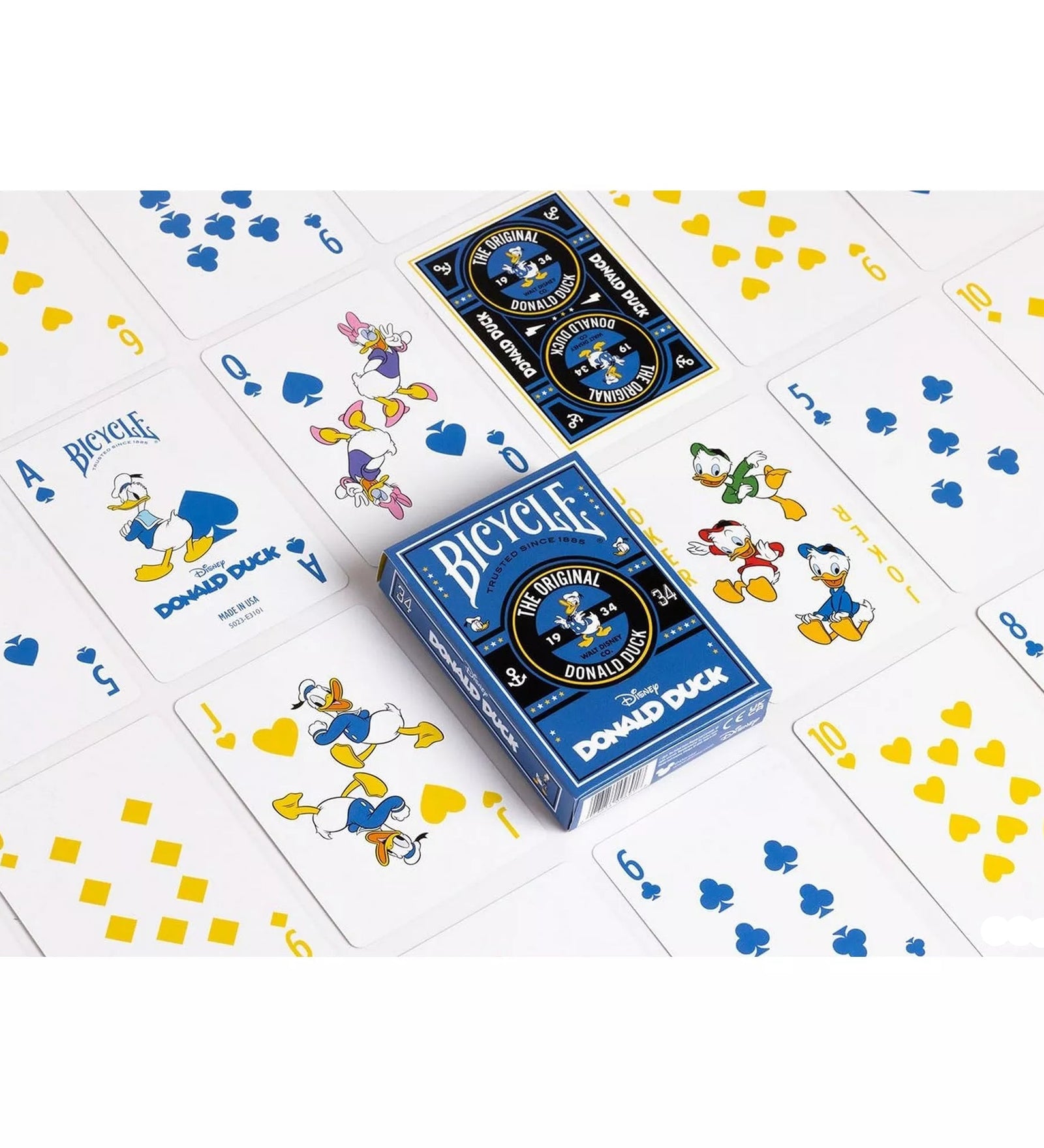 A Bicycle Donald Duck kártyapakli kiterítve, a lapokon Donald kacsa, Daisy és unokaöccsei láthatók, kék és sárga színű motívumokkal díszítve.