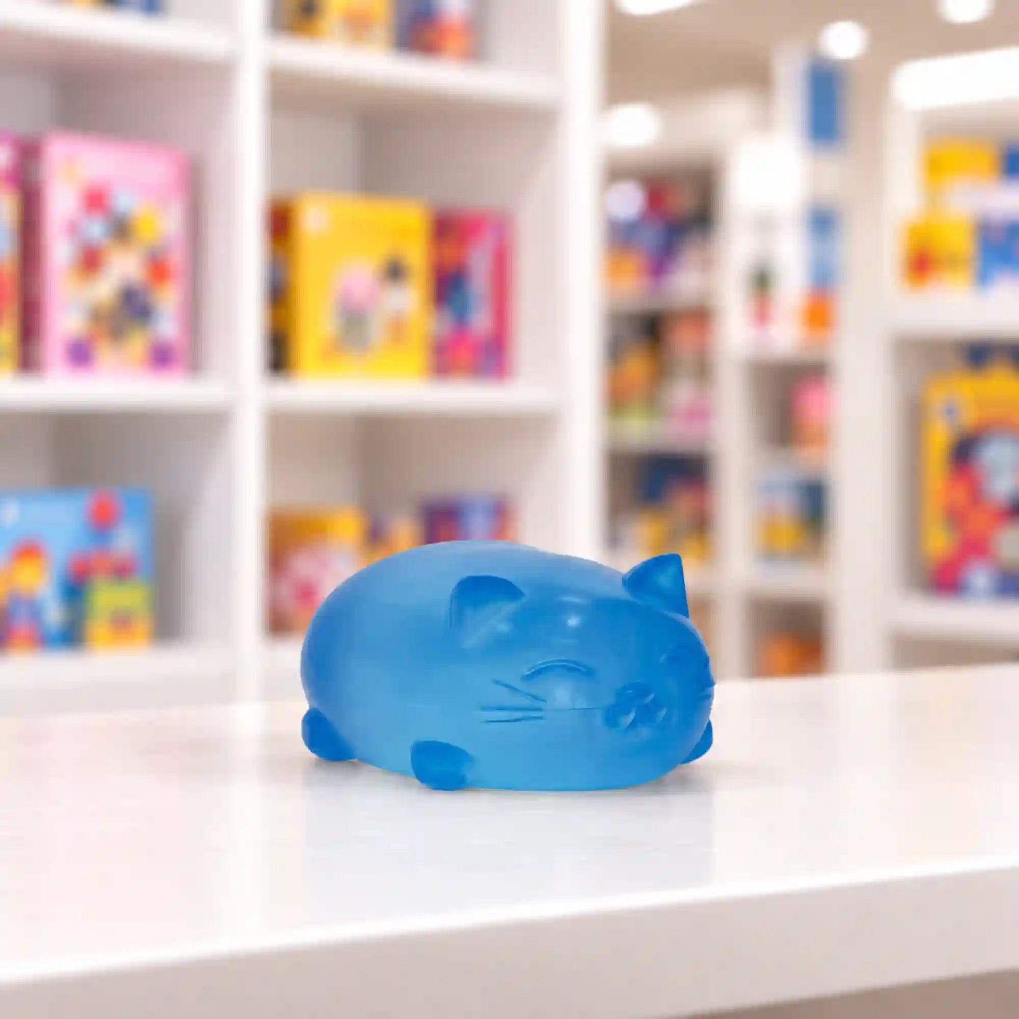 Cool Mix Super Gel kék cica stresszlevezető játék – áttetsző, puha zselés macskafigura üzleti környezetben, fehér asztalon