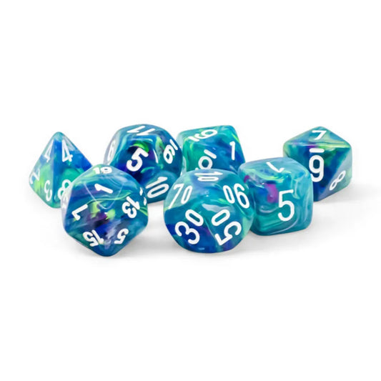 Chessex Festive Waterlily/white 7-darabos dobókocka készlet – Színpompás, kék-zöld-lila árnyalatú poliéderes dobókockák fehér számokkal, közelről fotózva.