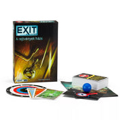 „EXIT – A rejtvények háza társasjáték tartalma: játékszabály, kártyapakli, dekódtárcsa, kék gömb és egyéb játékelemek a doboz mellett.”