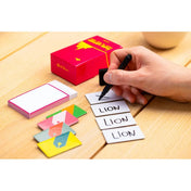 „Az Egy imposztor New Yorkban társasjáték kellékei az asztalon: kártyák, filctoll és jegyzetlapok, kézírással.”