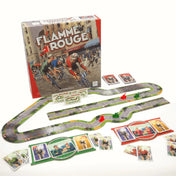 Flamme Rouge magyar nyelvű társasjáték doboza és teljes játékkészlete, moduláris versenypálya elemekkel, piros és zöld kerékpáros figurákkal, játékoskártyákkal és segédlapokkal egy asztalon elrendezve.