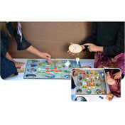 Társasjáték játék közben, játékosok kézzel mozgatják a bábukat a színes játéktáblán.