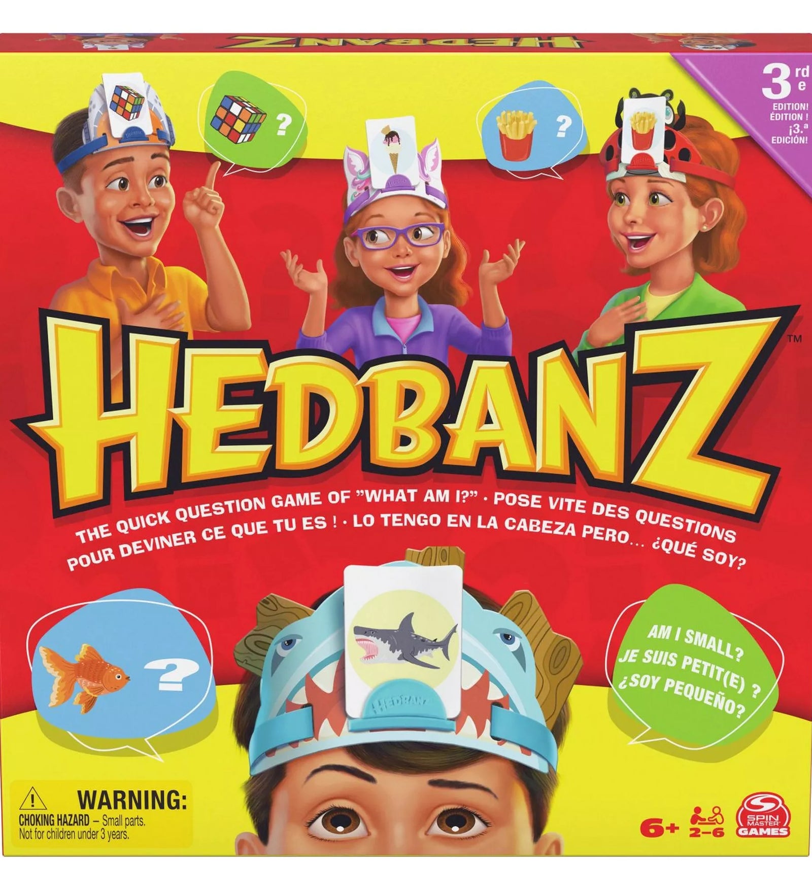 A Hedbanz társasjáték színes doboza, rajta gyerekek láthatók fejpántokkal és kártyákkal a fejükön, a játék logója és leírása jól kivehető.