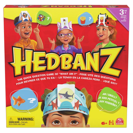 A Hedbanz társasjáték színes doboza, rajta gyerekek láthatók fejpántokkal és kártyákkal a fejükön, a játék logója és leírása jól kivehető.