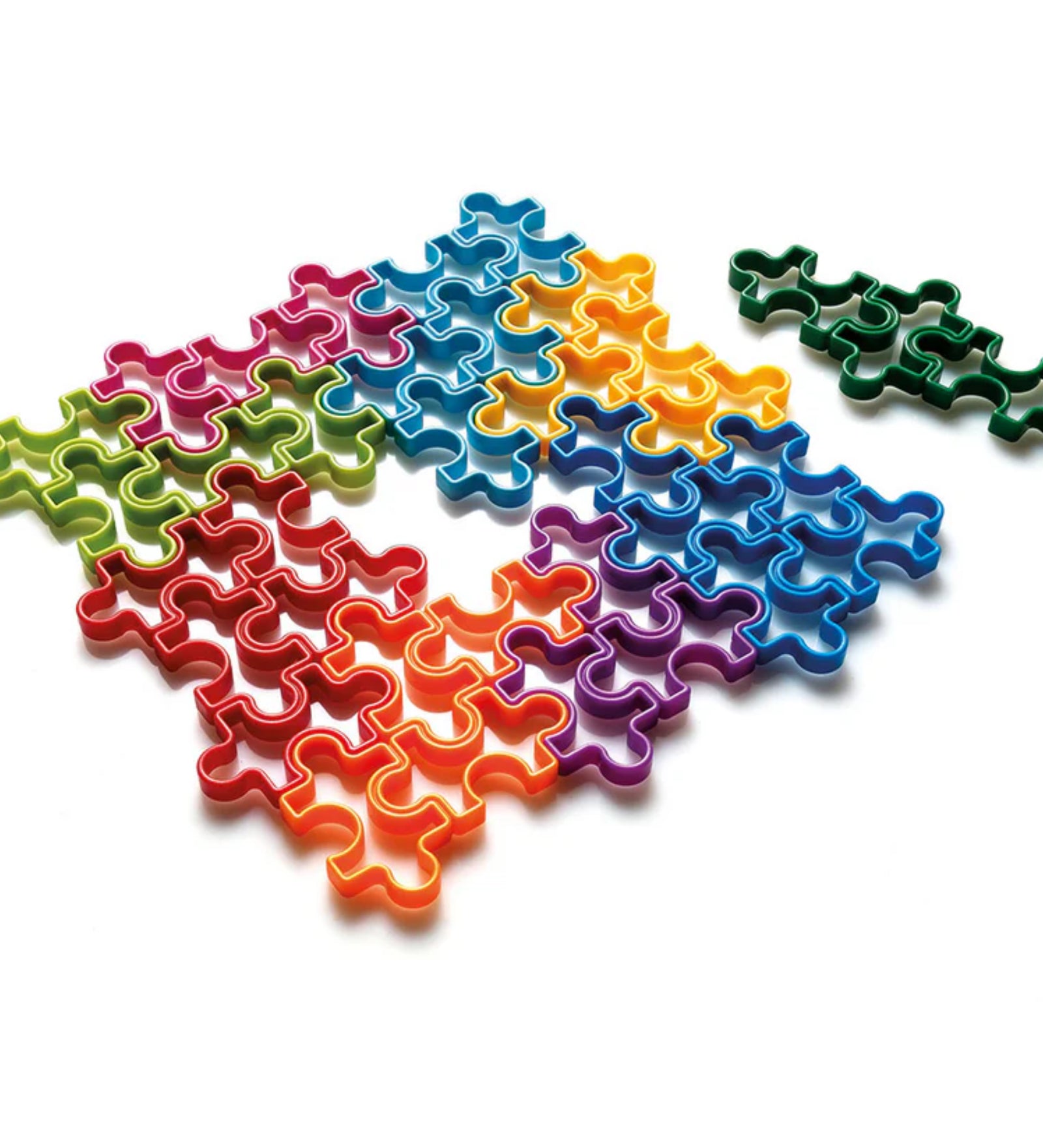 Az IQ Matrix logikai játék élénk színű, egymásba illesztett puzzle-elemei látszanak közelről, bemutatva a játék változatos formáit és élénk színeit, amikből egy teljes mátrix rakható ki.
