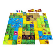 A Kingdomino társasjáték 2. kiadásának színes játéktáblája – különböző birodalmak mezőkkel, vízzel, erdőkkel és várakkal, négy játékos színes figuráival.