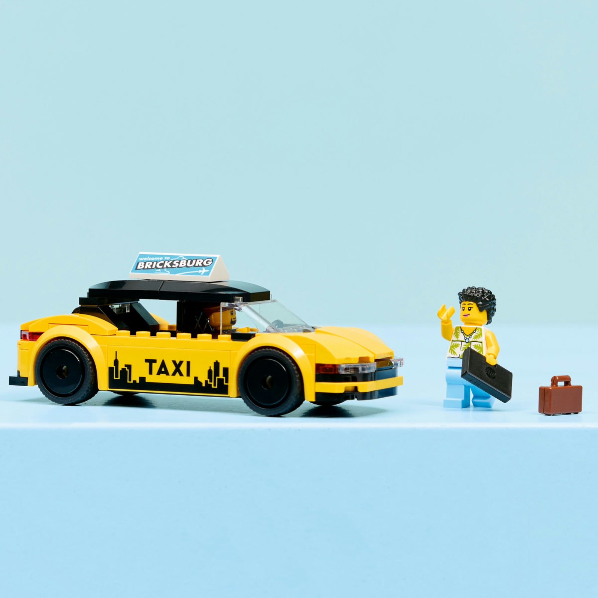 LEGO City Yellow Taxi (60487) – a megépített sárga taxi és az utas minifigura, kiegészítőkkel, stúdió háttérben.
