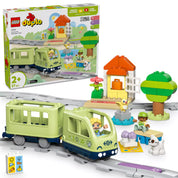 Kicsomagolt LEGO DUPLO 10427 Interaktív kalandvonat készlet: sínpályán haladó vonat, utasokkal, házikóval, fával, kutyával és akciókockákkal kiegészítve.
