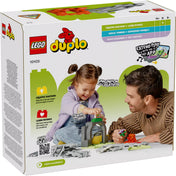 LEGO DUPLO Kiegészítő készlet - Alagút és Vasúti Sínek (10425) dobozának hátoldala, amelyen egy mosolygó kislány játszik egy alagút és sínek összeállításával egy felnőtt segítségével, ösztönözve a kreativitást és a finommotorikus készségek fejlesztését.