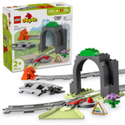 LEGO DUPLO Alagút és Vasúti Sínek kiegészítő készlet (10425) elemei, köztük egy szürke alagút, vasúti sínek, váltó, jelzőtábla és színes dekorációk, valamint a doboz illusztrációja a háttérben.