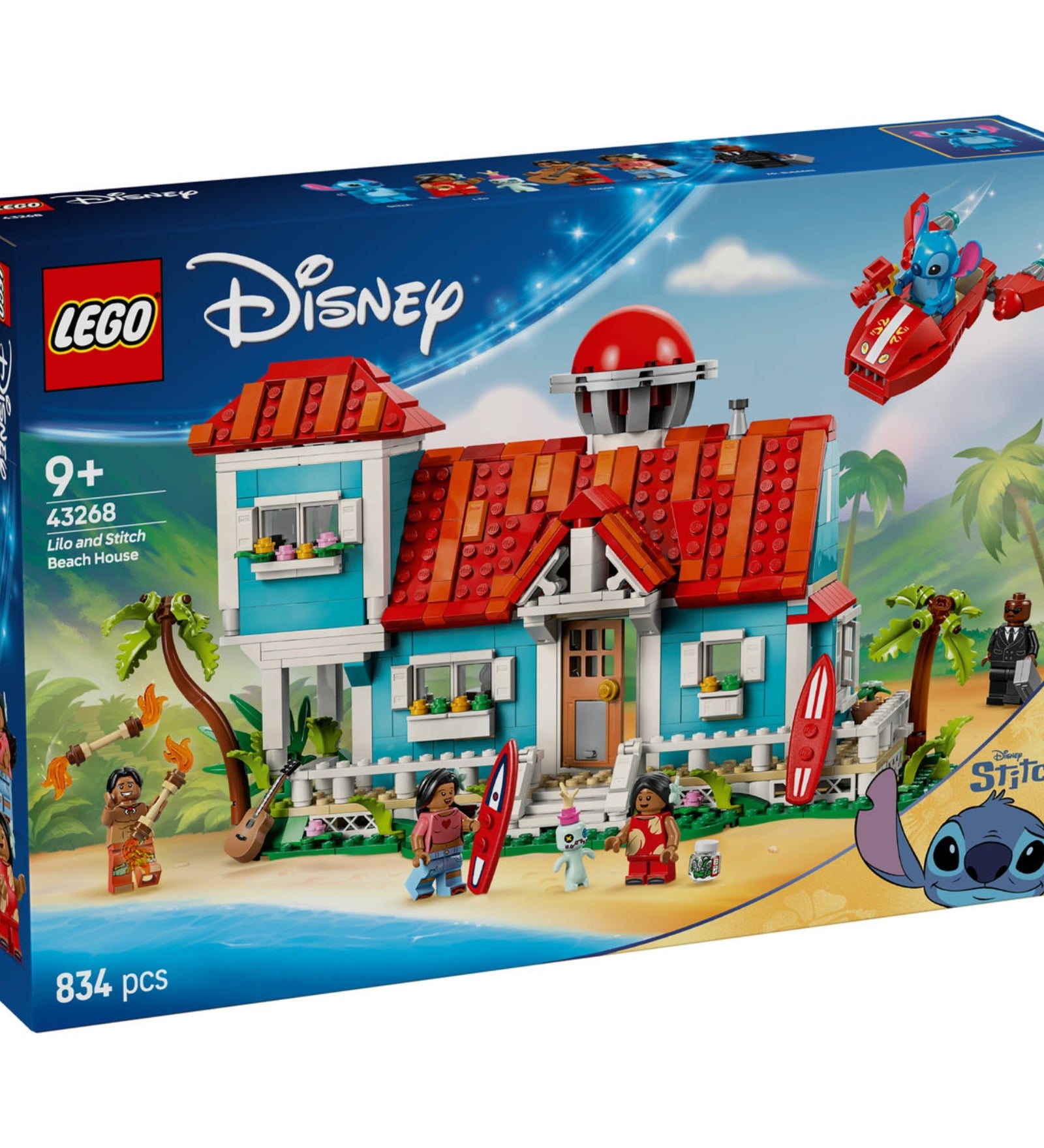 A képen a LEGO Disney Lilo és Stitch Tengerparti Háza (43268) készlet látható. Ez a színes, részletgazdag építőjáték egy ikonikus kék-fehér tengerparti házat ábrázol, piros tetővel és számos, a filmre jellemző elemmel. A doboz grafikája egy festői trópusi hátteret mutat, ahol Stitch egy piros űrhajóval repül, míg Lilo és családja a ház körül játszanak és pihennek. A készletben megtalálhatóak a népszerű szereplők, köztük Lilo, Stitch, Nani, David és Mr. Bubbles minifigurái, valamint extra kiegészítők, mint a