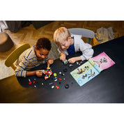 Gyerekek játszanak és építik a LEGO Dreamzzz Cooper tigrisrobotja és Zero hot rod autója (71497) szettet az építési útmutatóval.