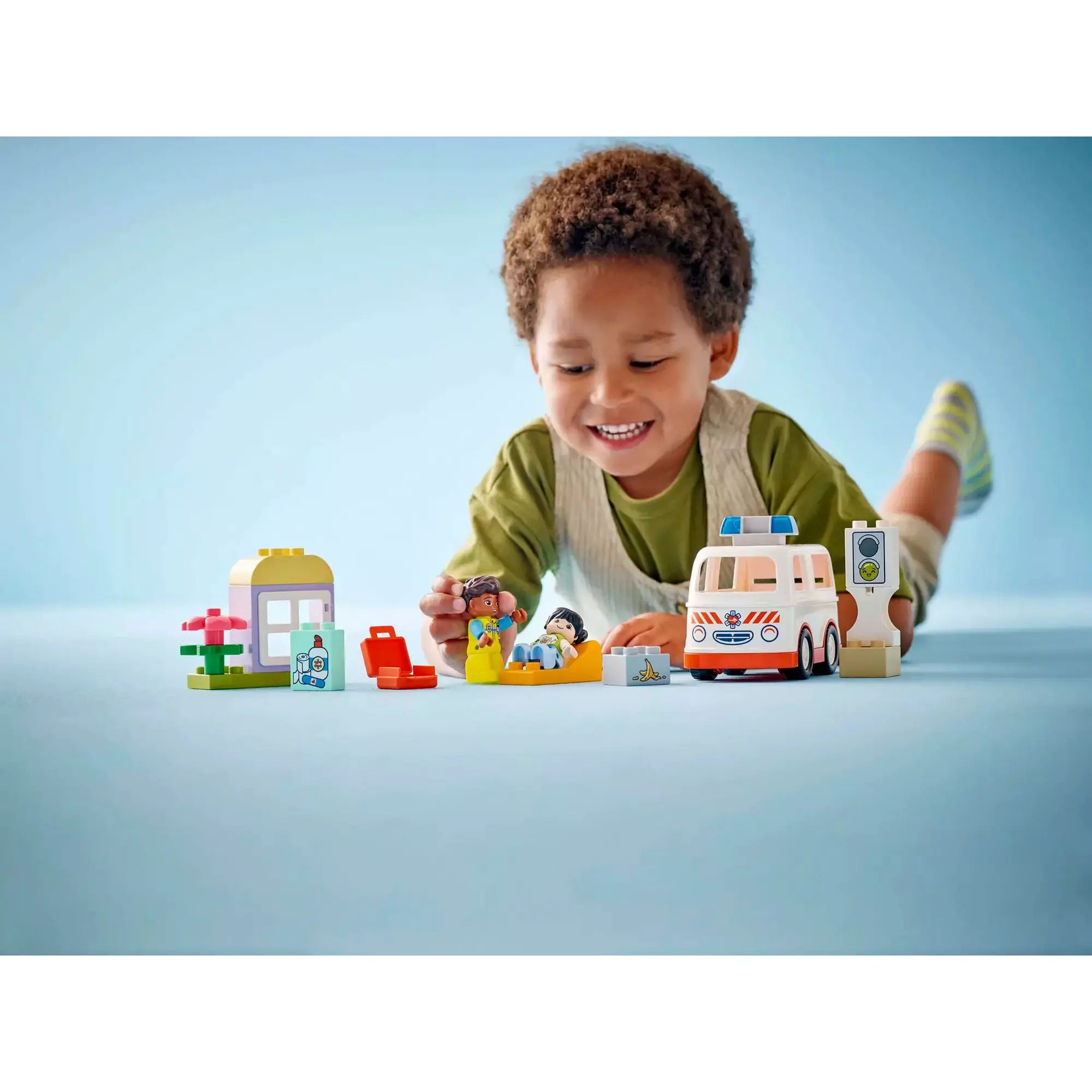 Egy kisgyermek játszik a LEGO Duplo Mentőautó és mentősofőr (10447) készlettel, bemutatva a mentőautó funkcióit és a szerepjáték izgalmait.