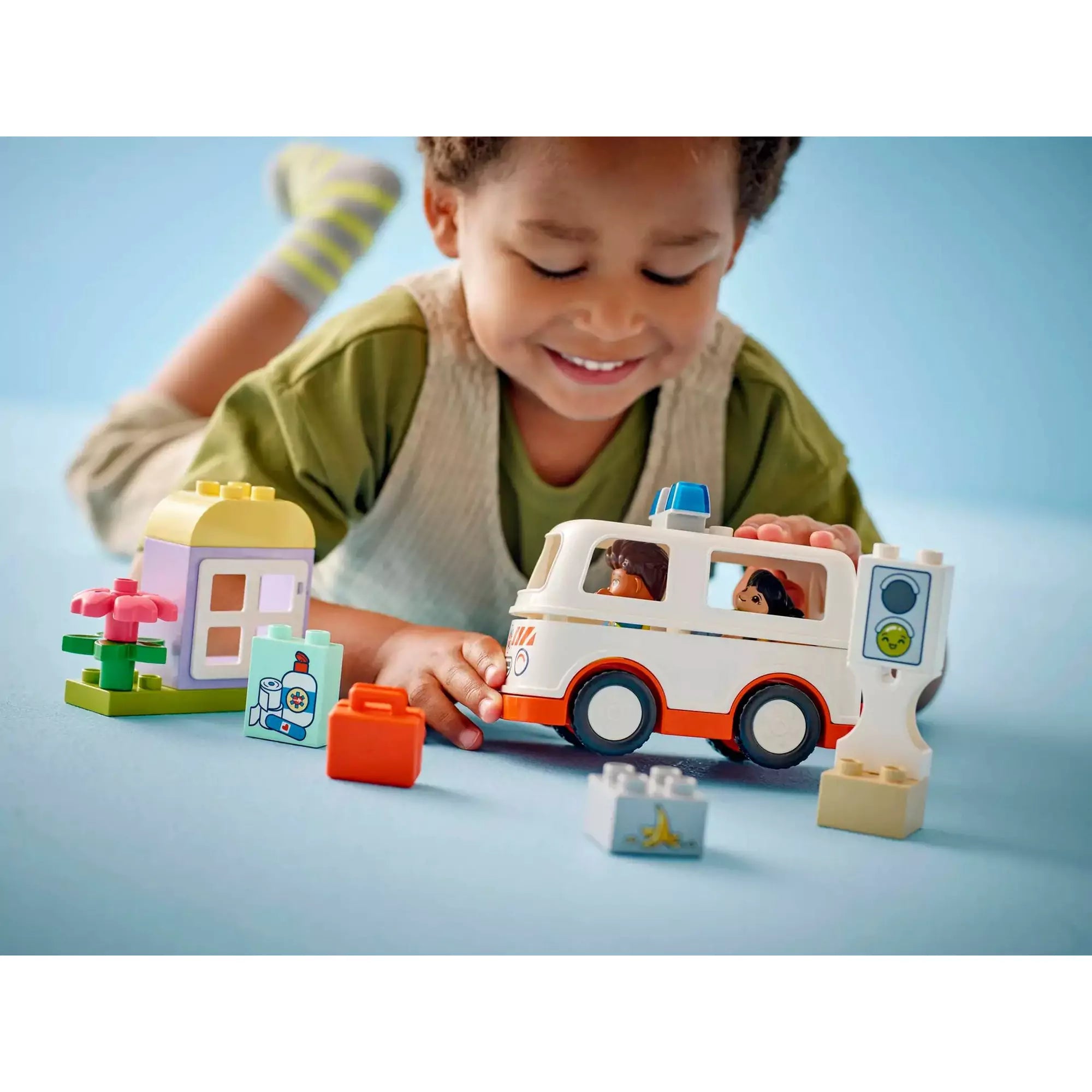 Egy kisgyermek játszik a LEGO Duplo Mentőautó és mentősofőr (10447) készlettel, bemutatva a mentőautó funkcióit és a szerepjáték izgalmait.