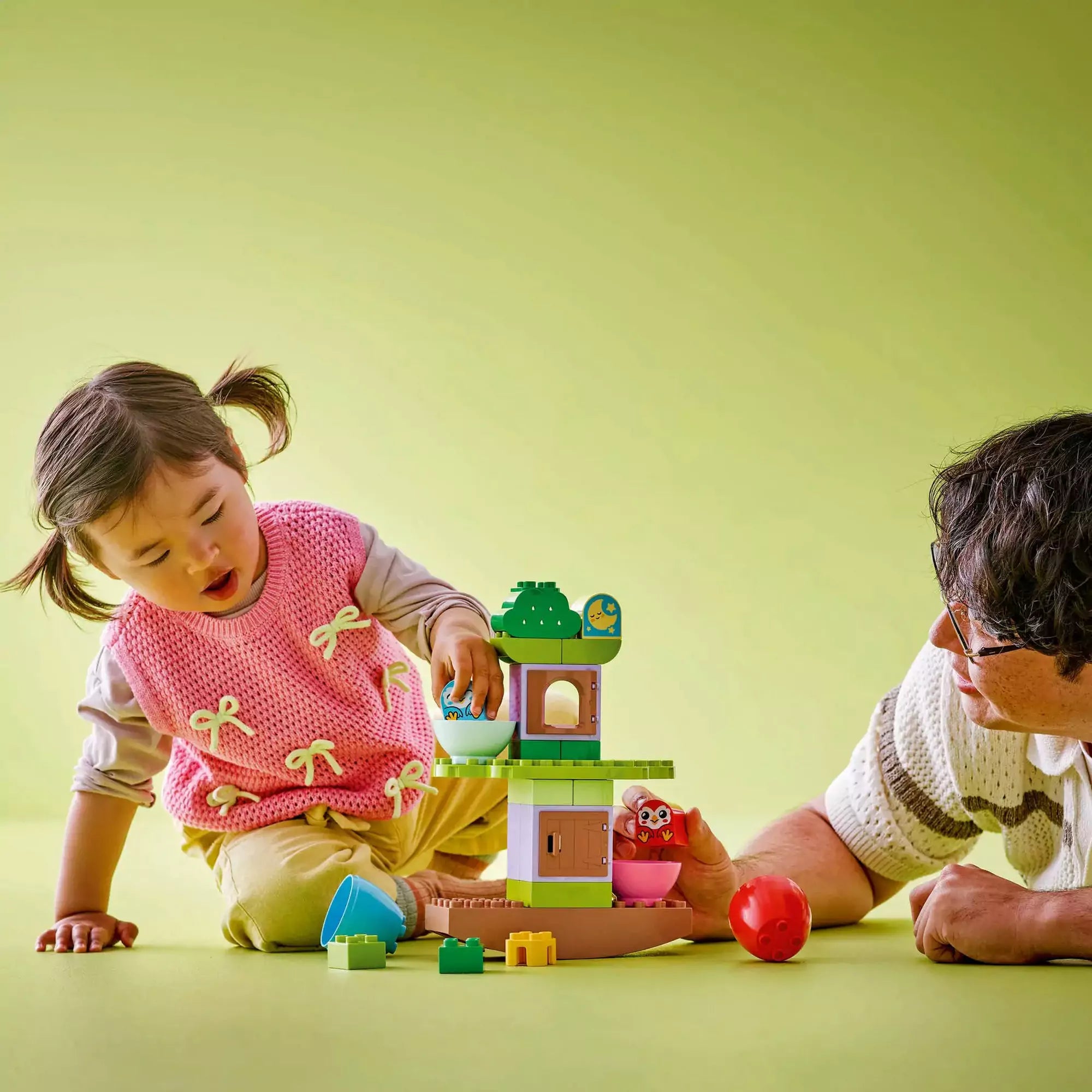 LEGO® DUPLO® Mérlegfa (10440) szett játék közben egy gyermek és egy felnőtt közös építési élményét bemutatva.