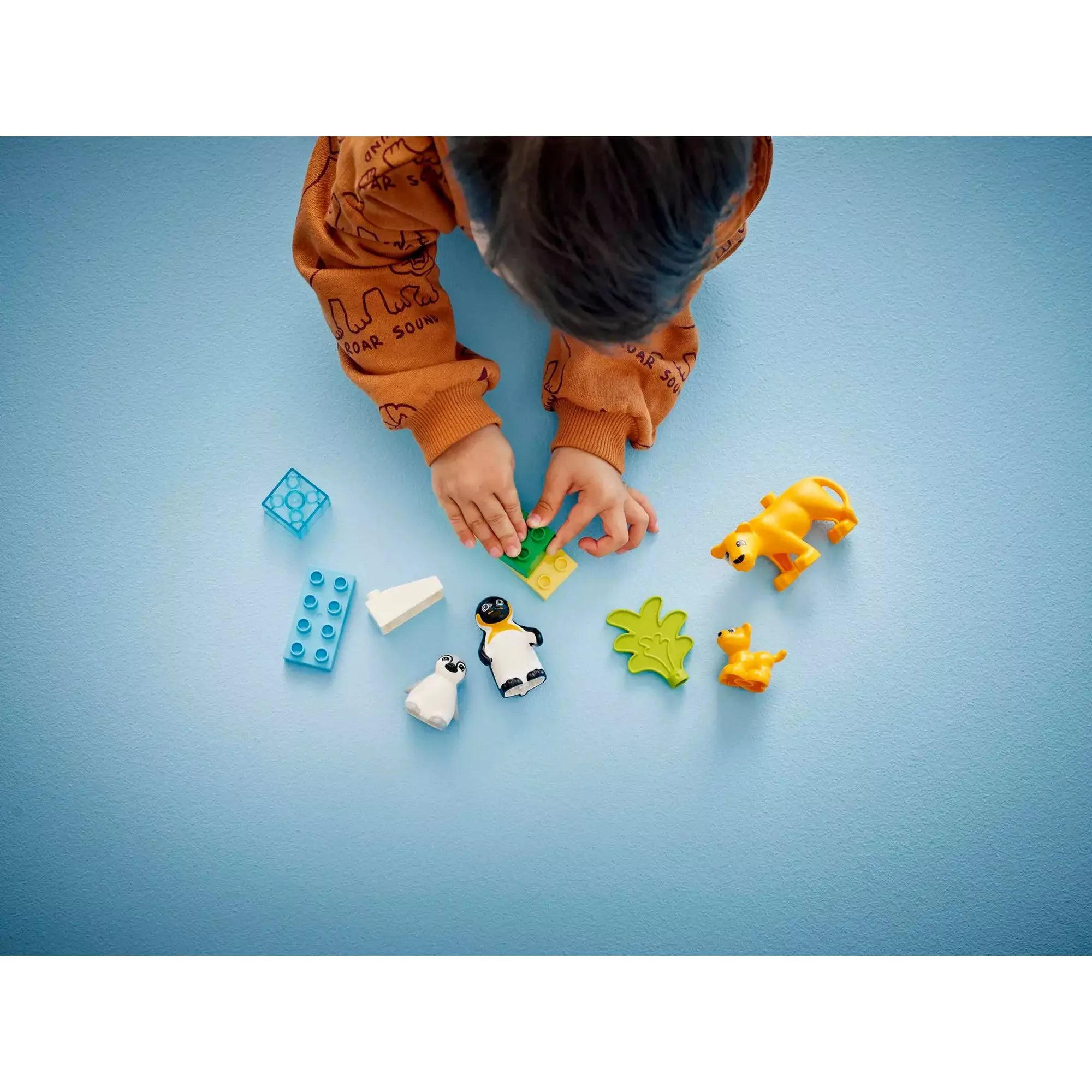 Gyermek játékkal LEGO Duplo Állatcsaládok a vadvilágban (10442): Gyerek kézzel építi a játék elemeit, színes állatfigurákkal és építőelemekkel.