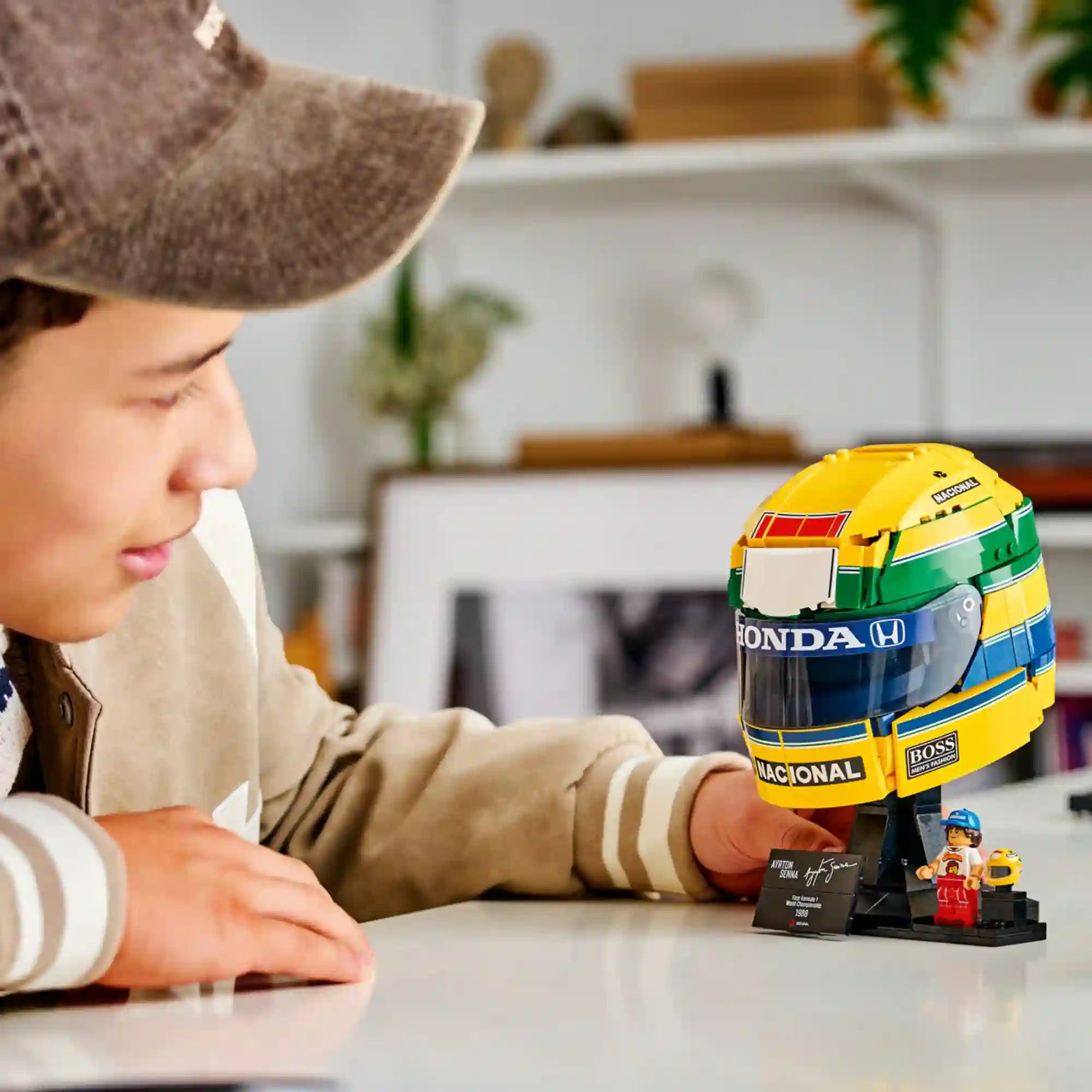 LEGO 43024 Ayrton Senna sisak – Fiatal az asztalon kiállított Ayrton Senna LEGO sisakmodellt nézi.