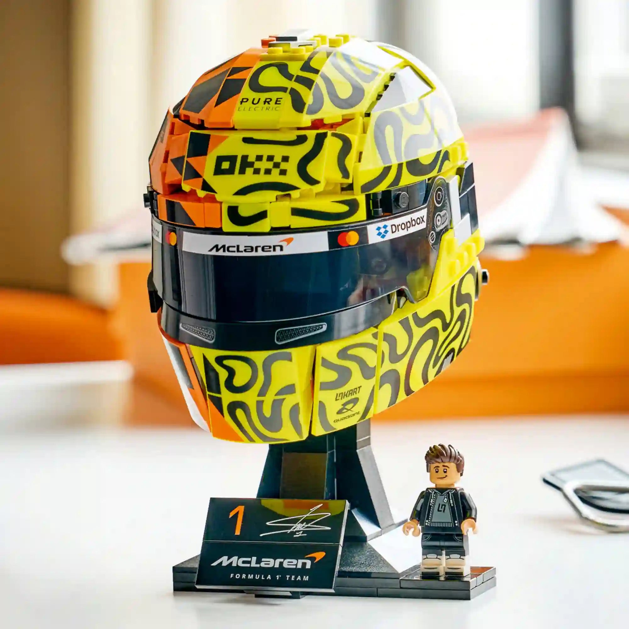 LEGO McLaren Mastercard F1 Team Lando Norris Helmet (43023) kiállítható sisakmodell állványon, Lando Norris minifigurájával és aláírásos névtáblával.