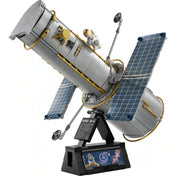 A LEGO Icons Hubble Űrteleszkóp 11382 részletgazdag modellje állványon, kihajtott napelemekkel és űrhajós minifigurával.