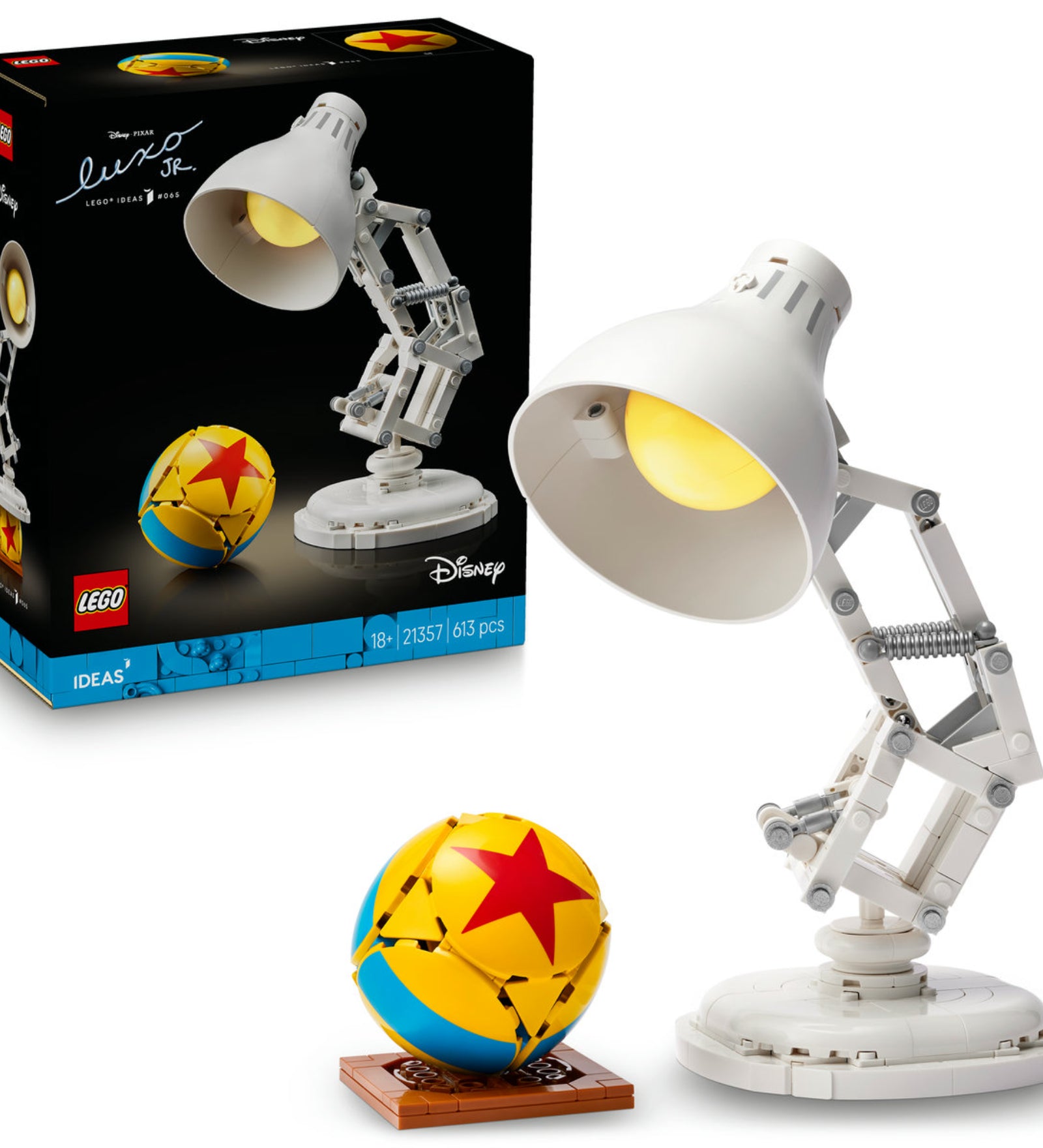 A LEGO Ideas Disney Pixar Luxo Jr. (21357) készlet összeépített modellje egy fehér, mozgatható íróasztali lámpával és egy sárga-kék labdával, a háttérben a termék doboza látható.
