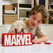 Fiú játszik a LEGO Marvel MARVEL logó és minifigurák (76313) szettel, Hulk, Vasember és Amerika Kapitány életre kelnek.
