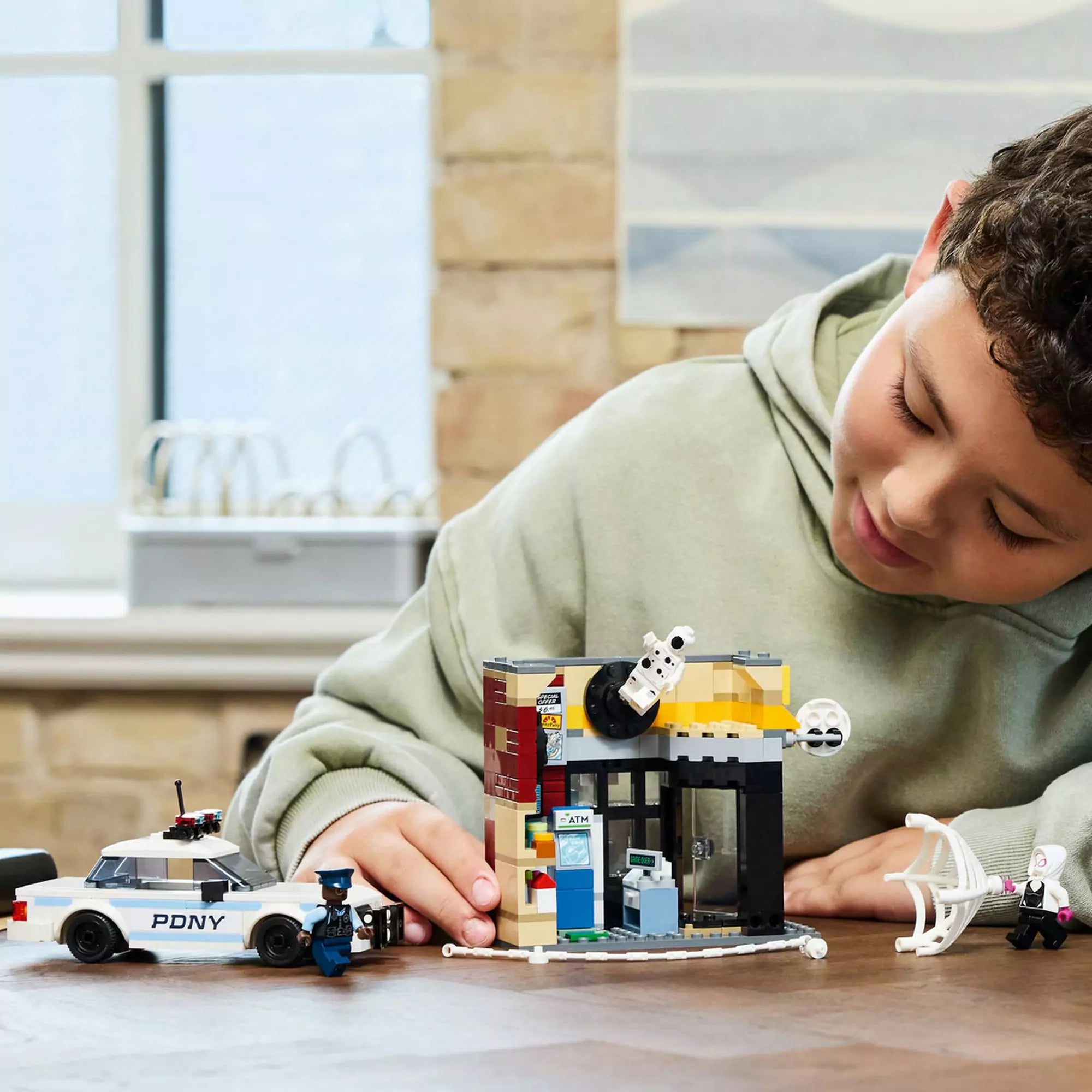 Egy gyerek játszik a ,,LEGO Pókverzum: Miles Morales vs. Spot 76311" szettel, amely izgalmas jelenetek újrajátszását teszi lehetővé.