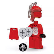 A LEGO Ninjago Kai világítós kulcstartó hátulról, nyitott elemtartóval, ahol látható a két CR2025 3V gombelem helye és a rögzítő csavarok.