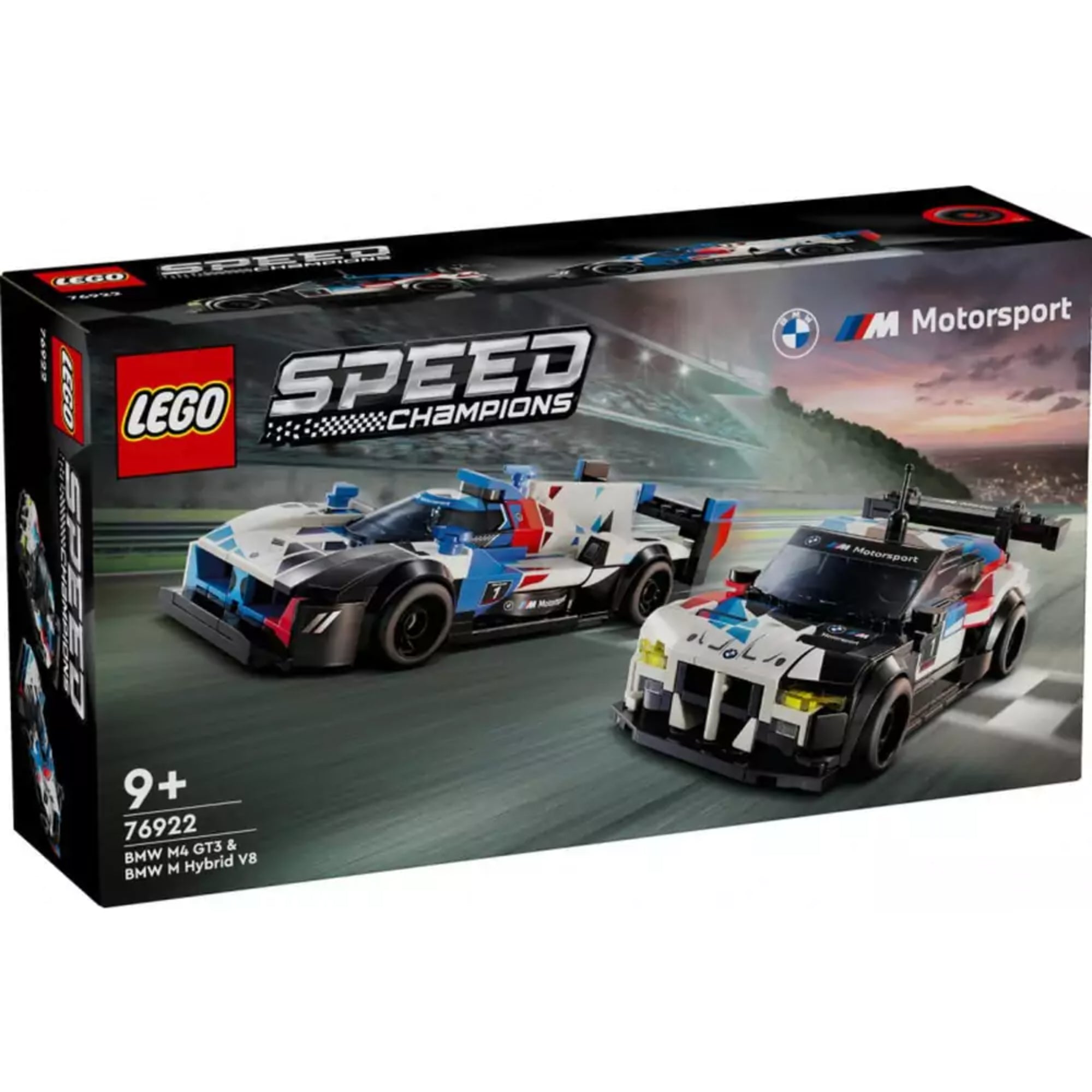 Részletgazdag LEGO Speed Champions 76922 szett doboza, amelyen két BMW versenyautó – a fehér–piros–kék színekben pompázó BMW M Hybrid V8 és a fehér–fekete BMW M4 GT3 – száguld egy versenypályán, a háttérben naplementével.