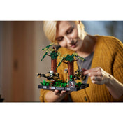 Egy szőke hajú nő kézben tartja és mozgatja a LEGO Endor sikló üldözés diorámát játék közben, jól láthatóak a részletesen kidolgozott fák és figurák.