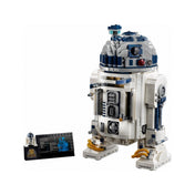A LEGO R2-D2 (75308) hátsó nézete, jól látható hátsó panelekkel, kábelekkel, a droidhoz tartozó narancssárga szerszámmal, információs táblával és minifigurával.