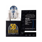 Közelkép az R2-D2 minifiguráról a LEGO 75308 készletből, fekete bemutatóállványon Lucasfilm 50 logóval és mellette technikai adatlappal.