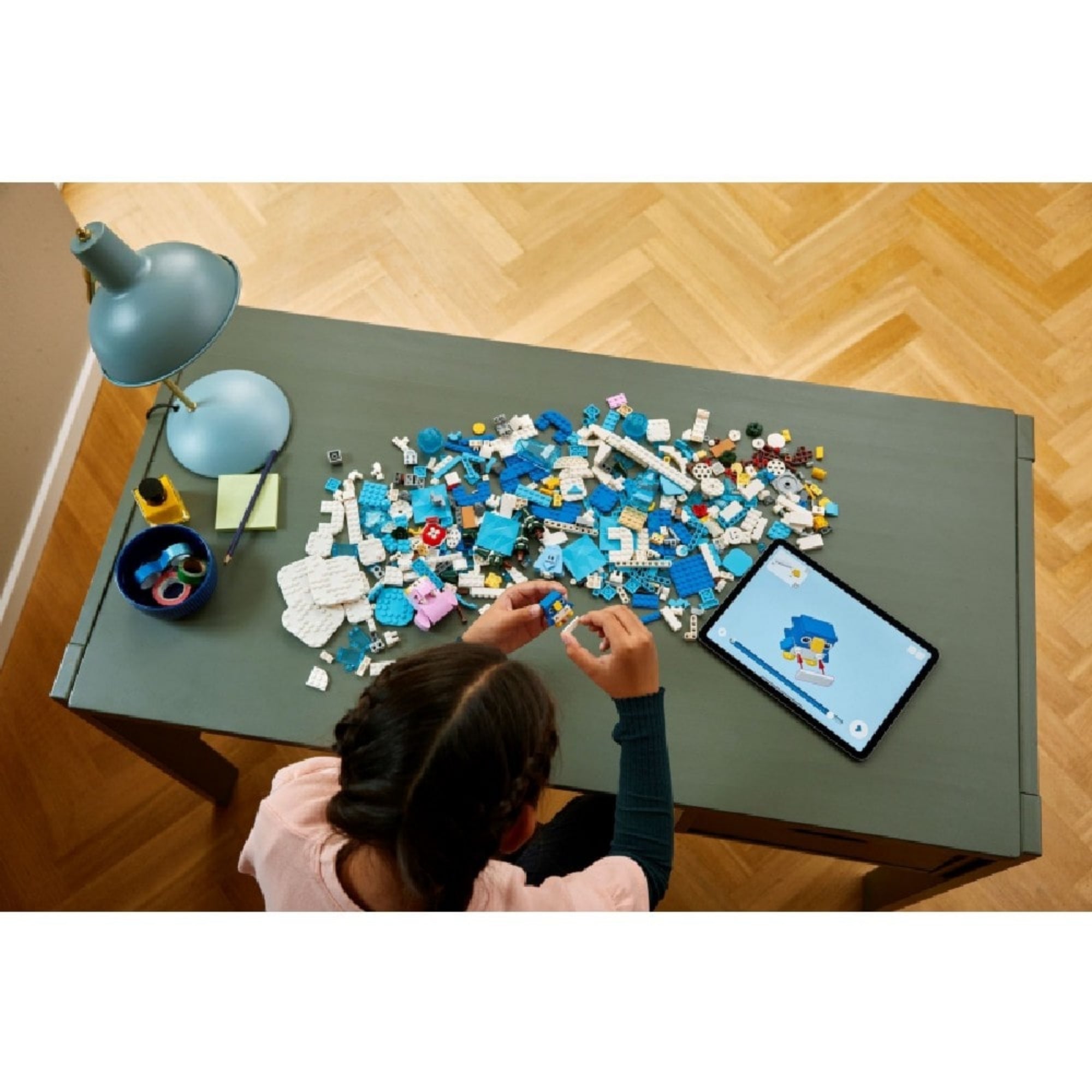 Egy gyermek épp a LEGO Super Mario Fliprus havas kaland szett darabjait építi, mellette tablet a digitális útmutatóval.