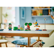 Egy otthoni környezetben lévő asztalon felállítva látható az egész LEGO Super Mario 71440 szett: Luigi, Baby Yoshi, Boo, Kamek és a különböző pályaelemek színes összeállítása.