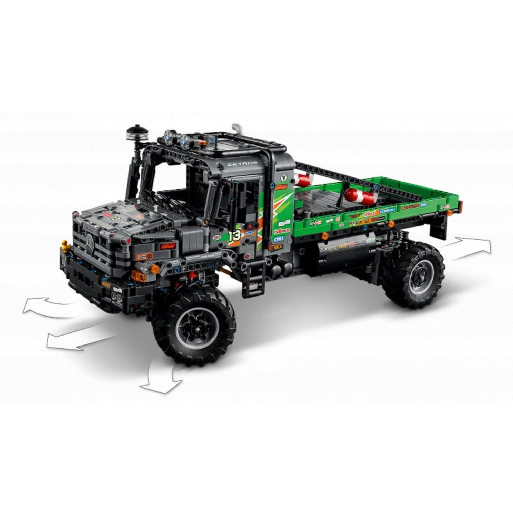 A LEGO Mercedes-Benz Zetros verseny teherautó modell bemutatva mozgó alkatrészekkel és kormányozható kerekekkel, fehér nyilakkal jelölve a mozgási irányokat.