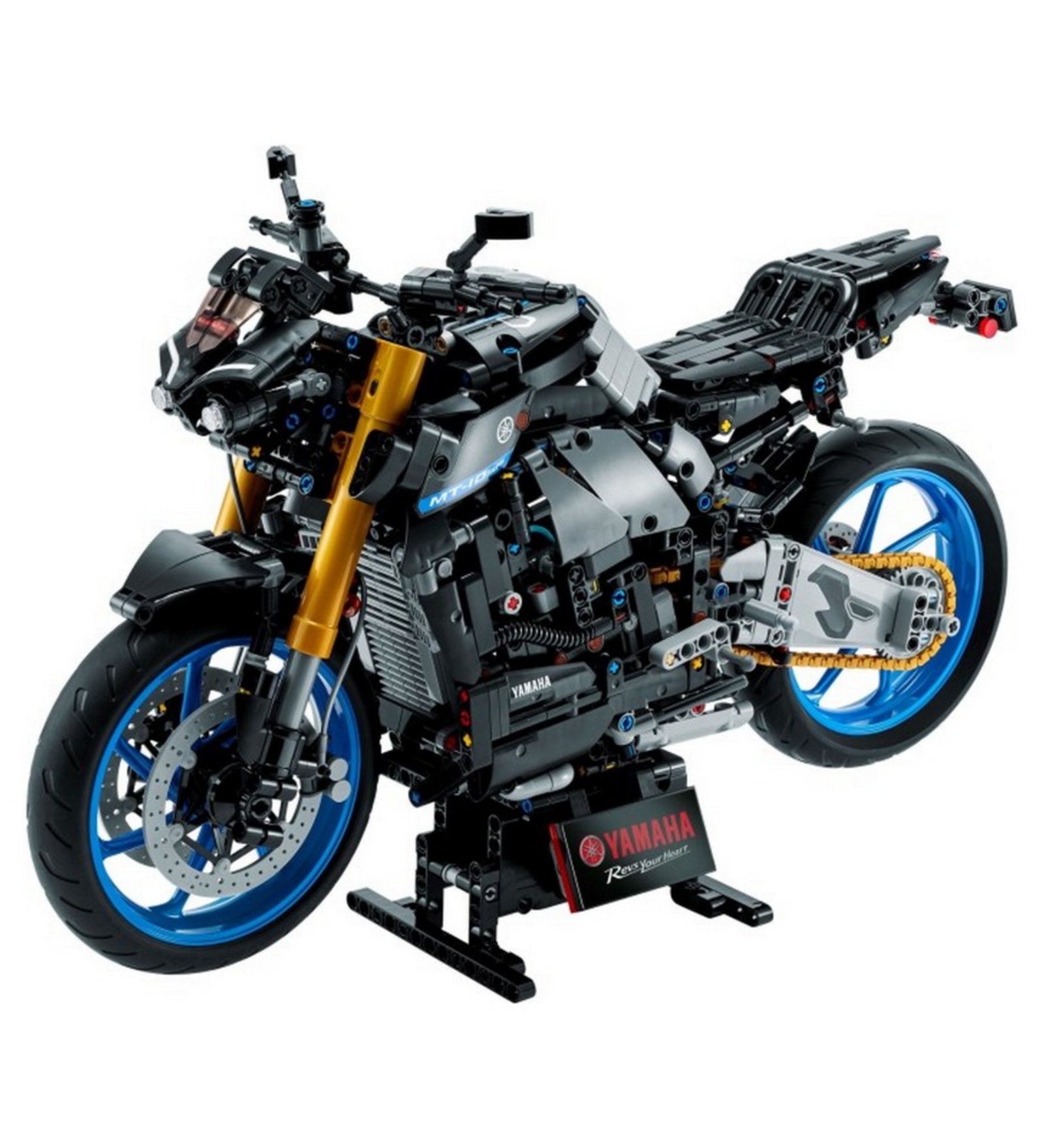 LEGO Technic Yamaha MT-10 SP 42159 modell ferde elölnézetből, aranyszínű első villákkal, kék keréktárcsákkal és a Yamaha logóval ellátott állványon.