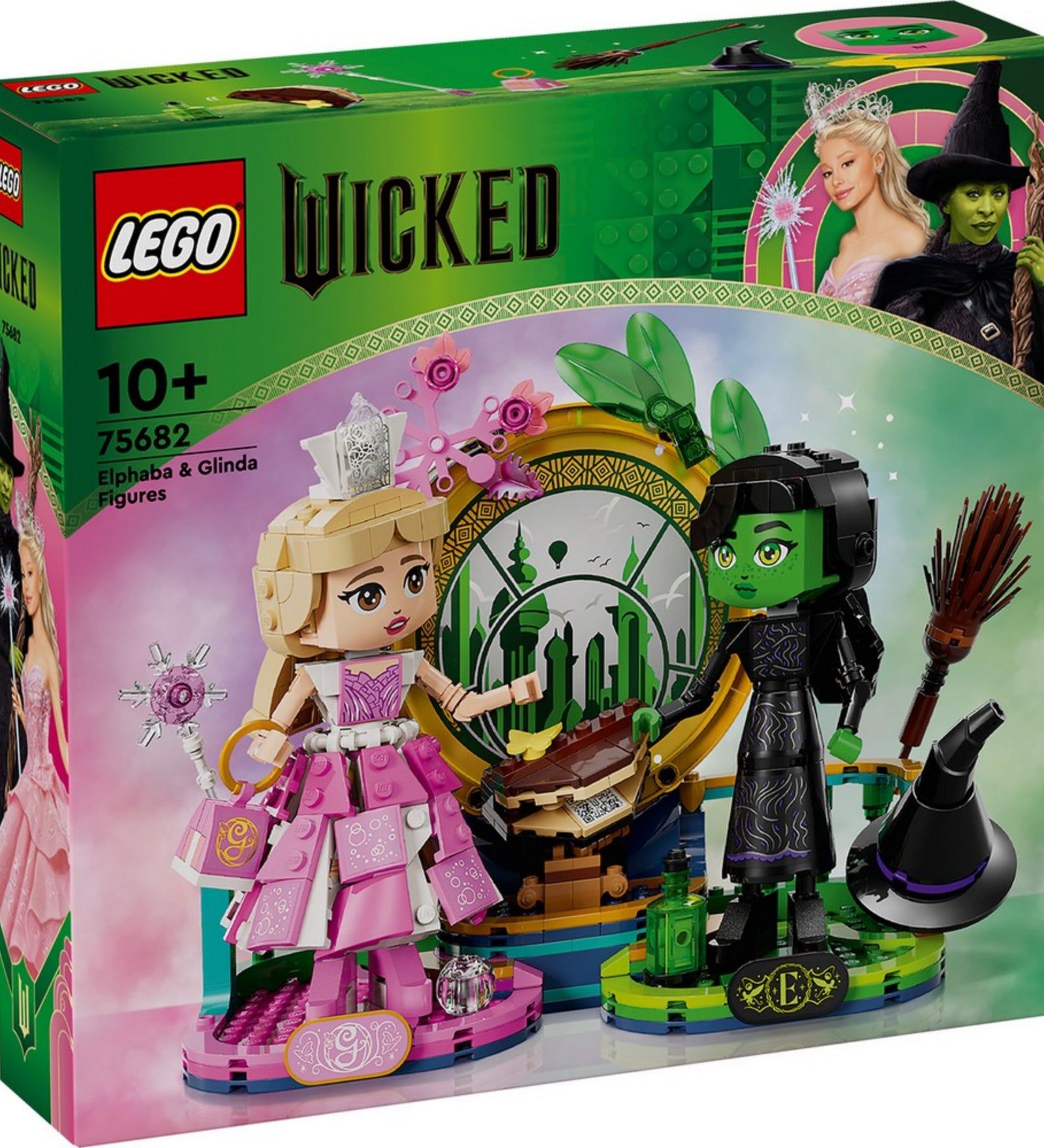A készlet doboza, amely Elphaba és Glinda figuráit, valamint a varázslatos zöld dekorációt mutatja be a háttérben a Smaragdvárossal.