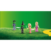 LEGO Wicked Glinda és Elphaba kollégiumi szobája (75683) készlethez tartozó négy LEGO minifigura, zöld füves háttér előtt, átváltoztatható ruhákkal.