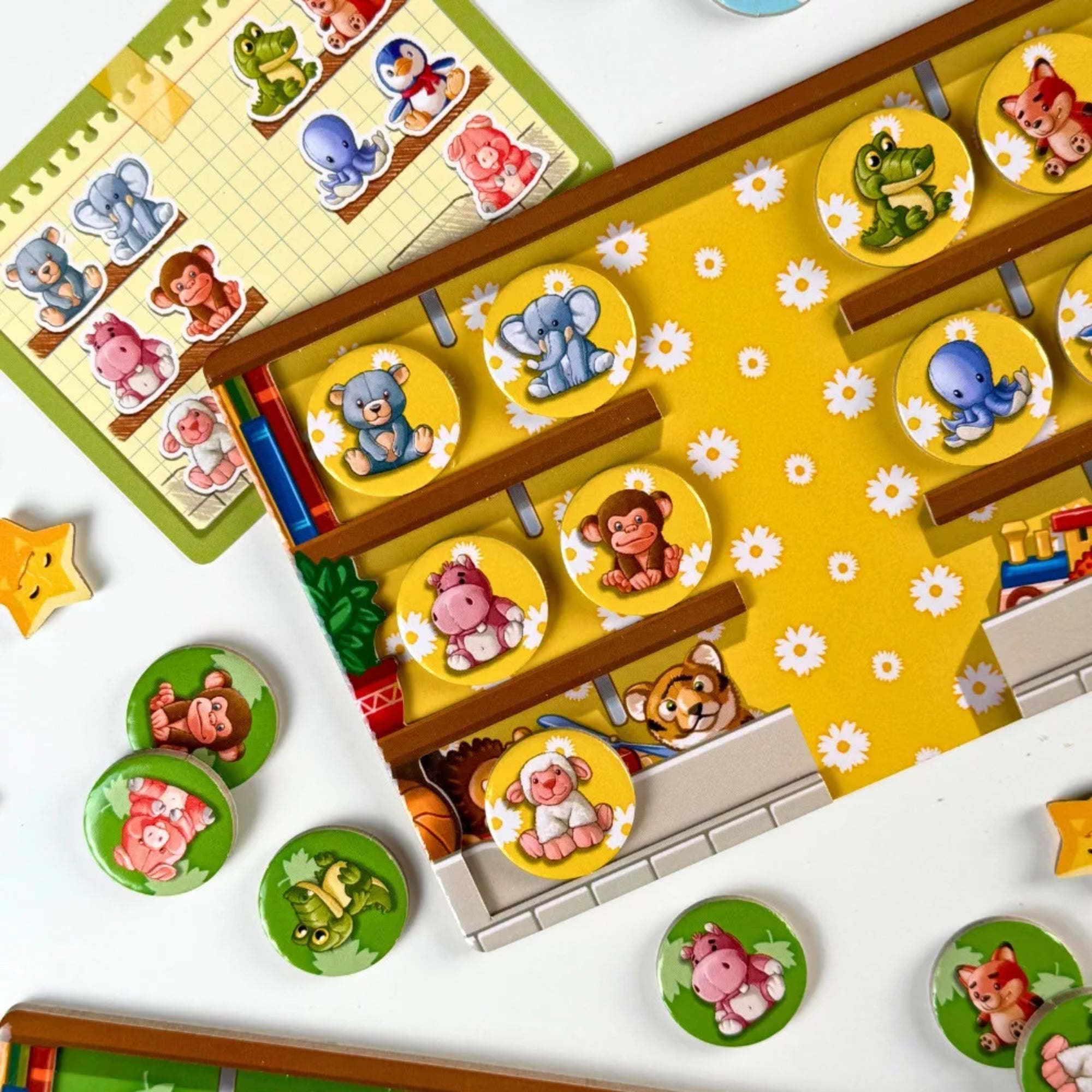 Laia társasjáték részlet a játéktábláról sárga háttérrel, állatfigurás korongokkal és feladatkártyával.