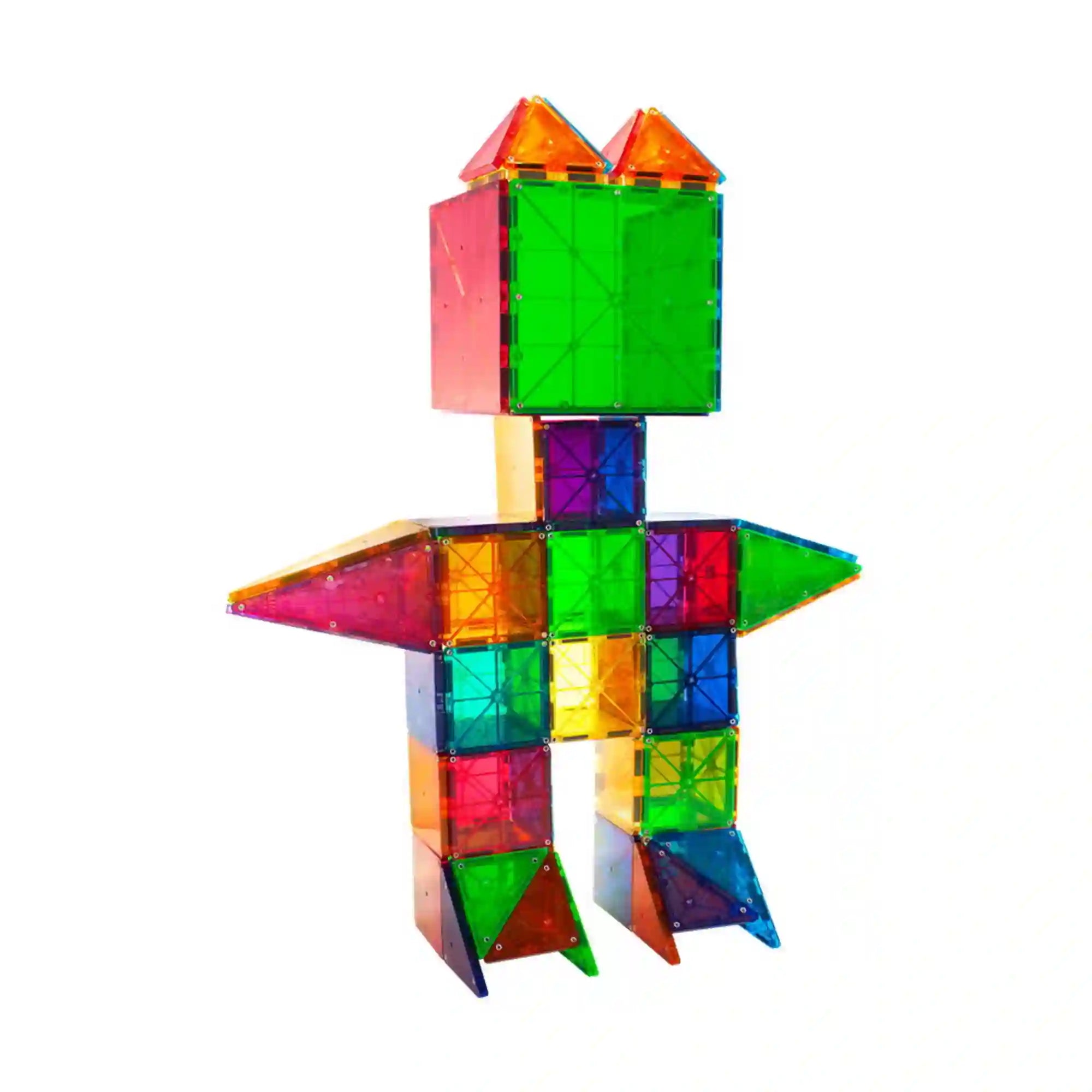 Egy kislány a MAGNA-TILES Clear Colors 100 darabos készlet színes, áttetsző mágneses elemekből épített robotfigurája mögött ül a padlón.