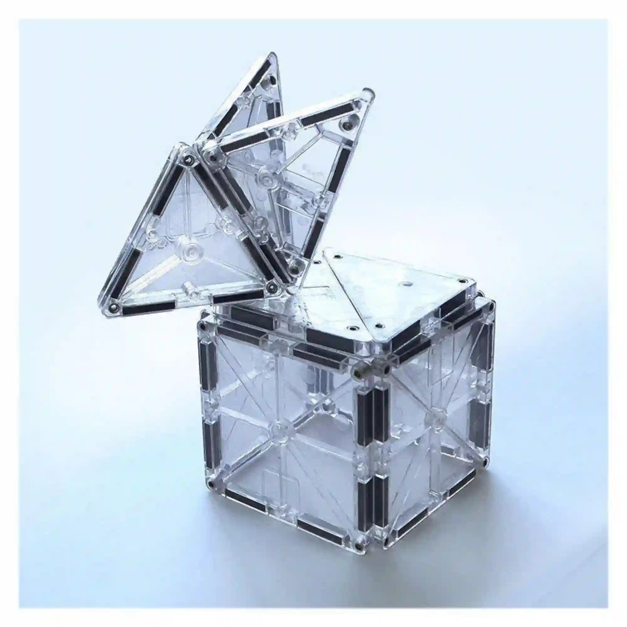 MAGNA-TILES Ice átlátszó mágneses négyzetekből épített kocka, tetején felfelé álló háromszög alakú elemekkel.